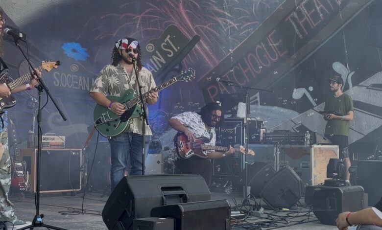 Three members of the band can be seen on a stage with a colofrul background during a performance